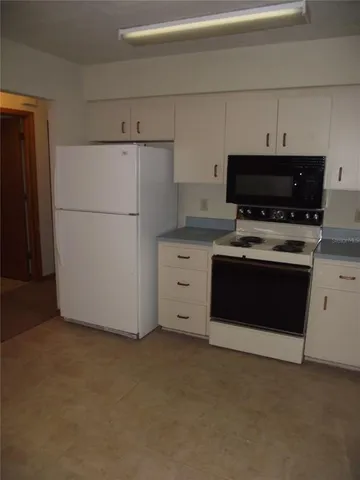 a kitchen with granite countertop white cabinets and sink