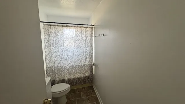 a bathroom with a toilet and a shower