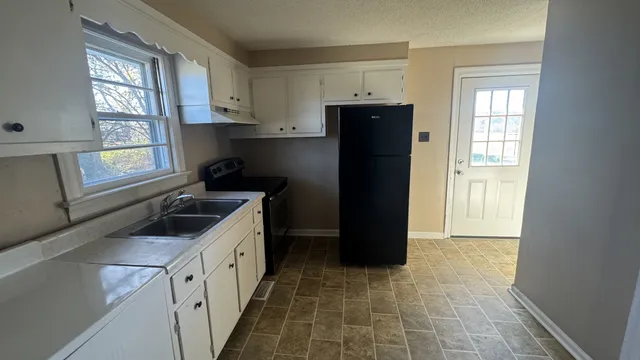 a kitchen with a refrigerator and a sink