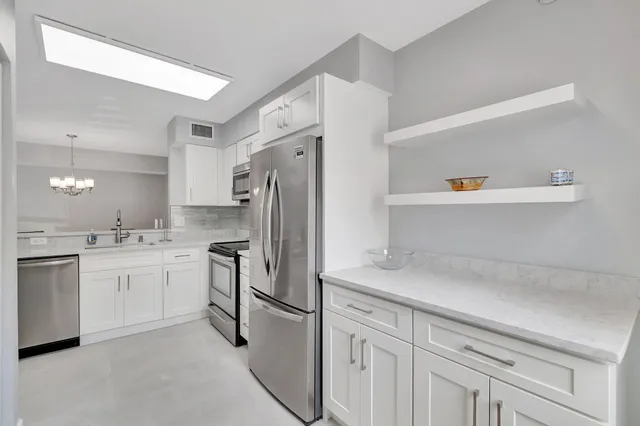 a kitchen with stainless steel appliances granite countertop a refrigerator and a stove