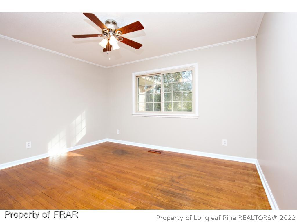 426 Hallmark Road Fayetteville, NC 28303 - Photo 19 of 36 an empty room with wooden floor and ceiling fan