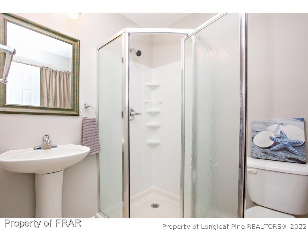 426 Hallmark Road Fayetteville, NC 28303 - Photo 30 of 36 a bathroom with a sink a toilet a shower and a mirror