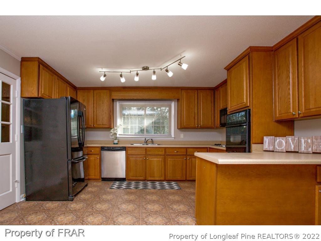 426 Hallmark Road Fayetteville, NC 28303 - Photo 6 of 36 a kitchen with stainless steel appliances granite countertop a sink refrigerator stove microwave and cabinets