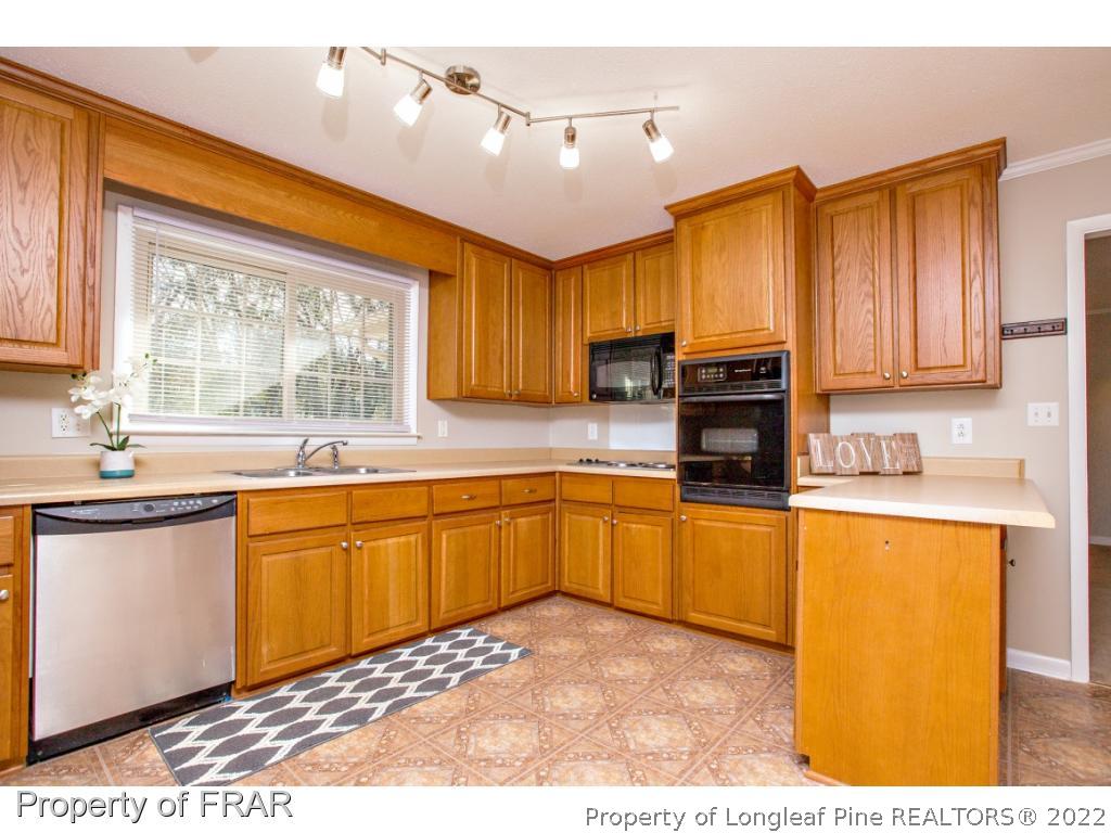 426 Hallmark Road Fayetteville, NC 28303 - Photo 7 of 36 a kitchen with stainless steel appliances granite countertop a stove a sink dishwasher and a microwave oven with cabinets