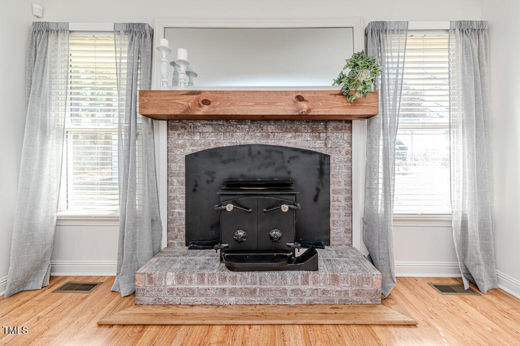 117 Johnson Street Broadway, NC 27505 - Photo 12 of 29 a living room with a fireplace and windows