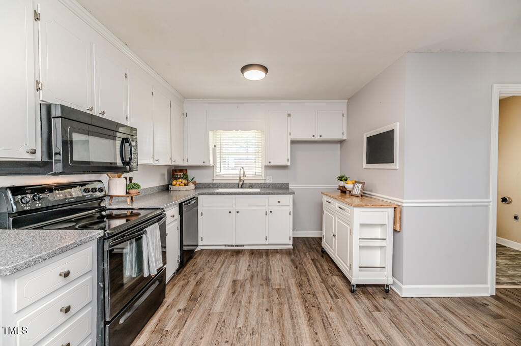 117 Johnson Street Broadway, NC 27505 - Photo 4 of 29 a kitchen with a sink wooden floor and stainless steel appliances