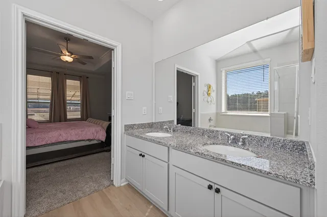 a en suite bathroom with a granite countertop sink and a mirror