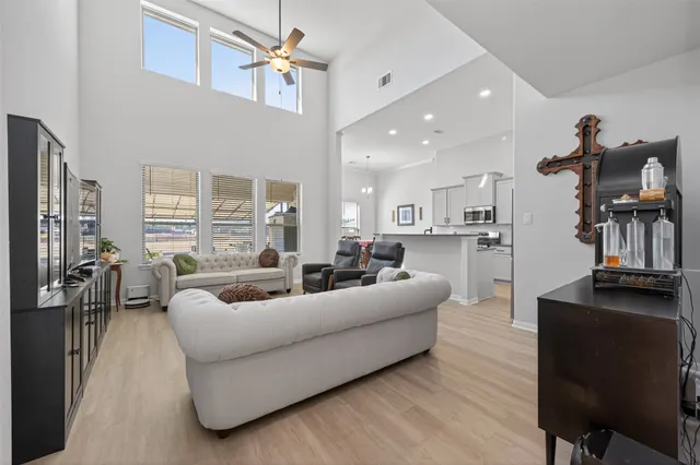a living room with furniture a chandelier and a flat screen tv