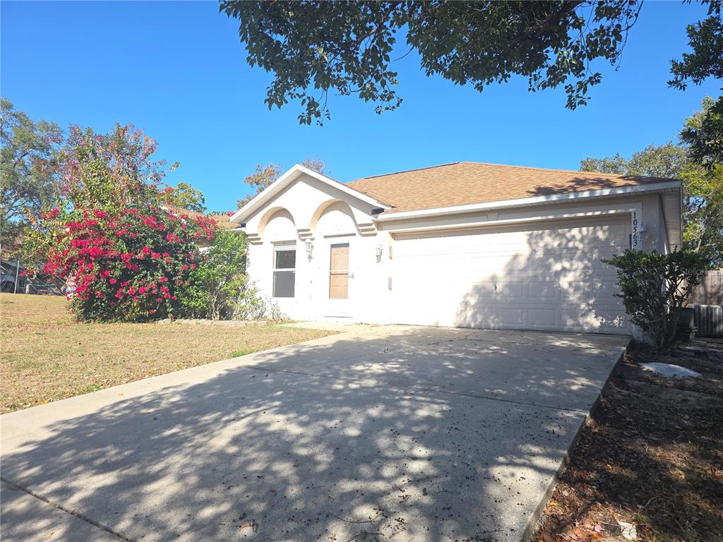 10563 Marysville Street Spring Hill, FL 34608 - Photo 2 of 22 a front view of a house with a yard and garage