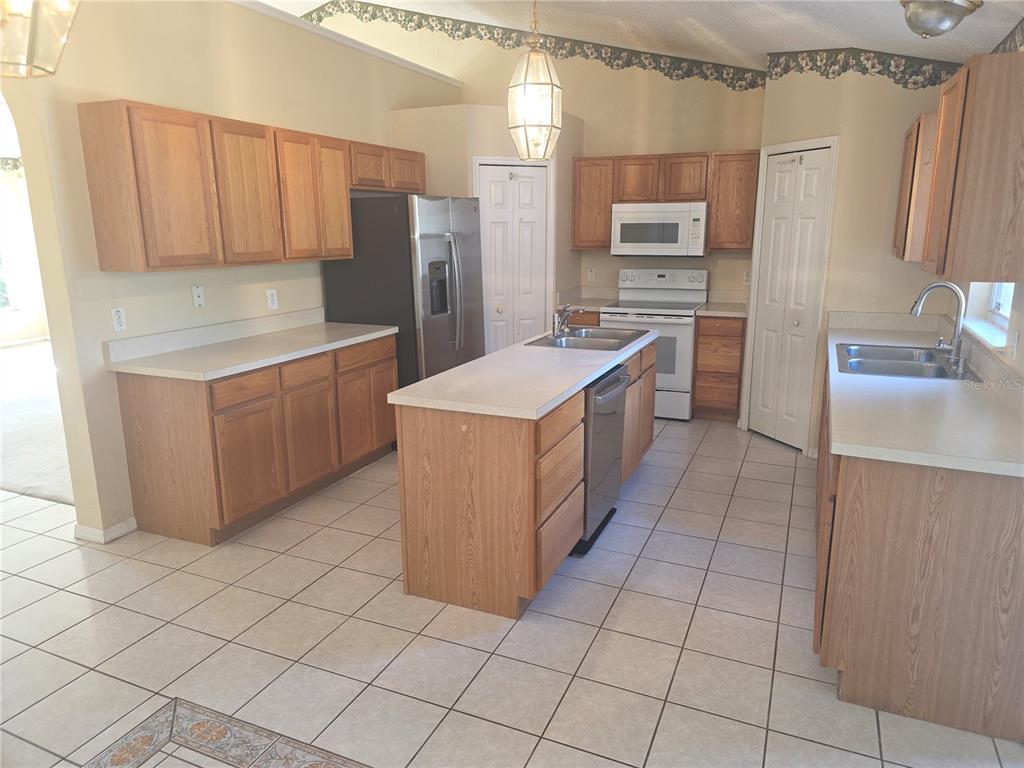 10563 Marysville Street Spring Hill, FL 34608 - Photo 3 of 22 a kitchen with stainless steel appliances a sink and a refrigerator