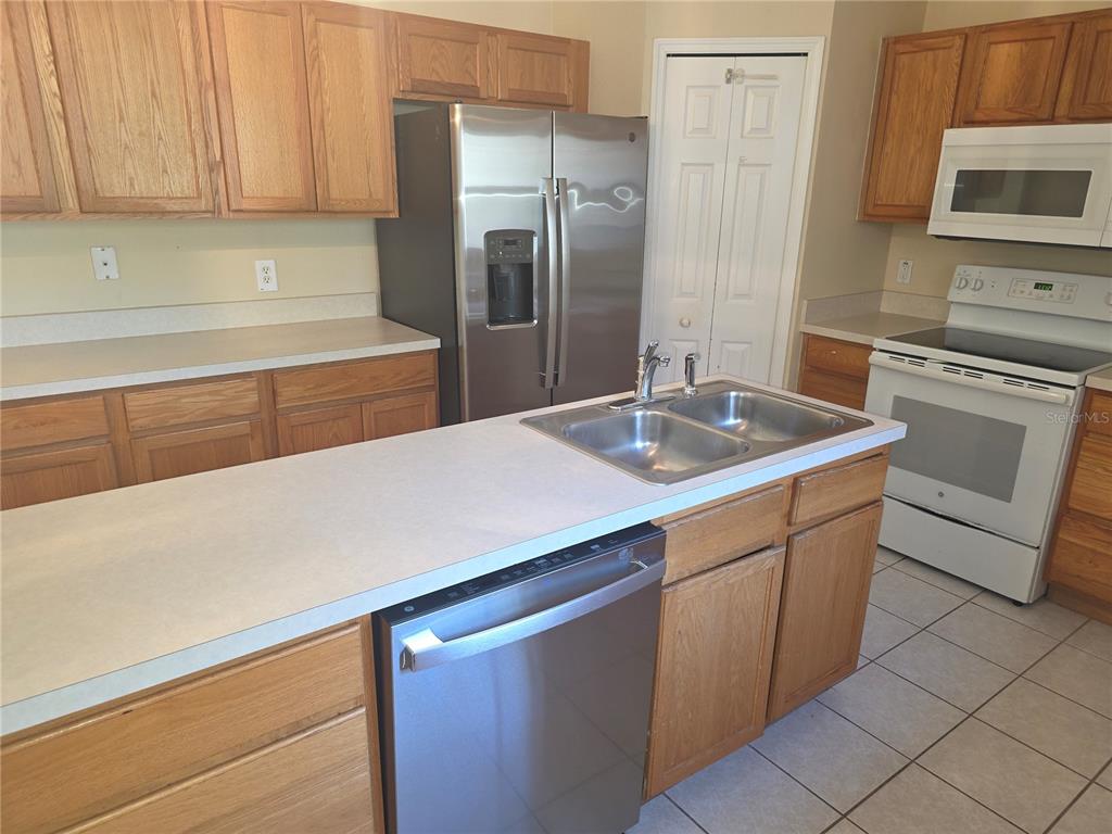 10563 Marysville Street Spring Hill, FL 34608 - Photo 6 of 22 a kitchen with stainless steel appliances granite countertop a sink a stove and refrigerator