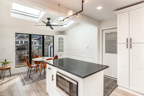a kitchen with a stove a refrigerator and a dining table with wooden floor