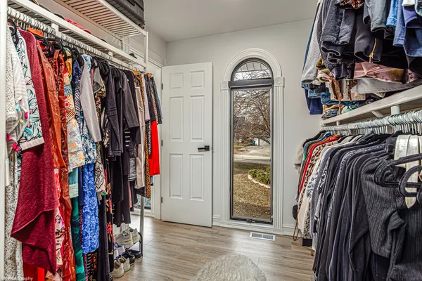 a view of walk in closet with clothes and shoes