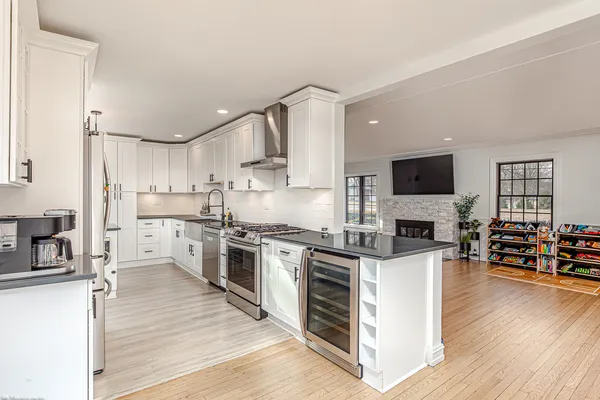 a kitchen with stainless steel appliances a stove top oven a sink dishwasher and a refrigerator