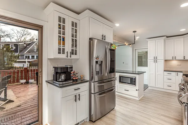 a kitchen with stainless steel appliances granite countertop a refrigerator and a stove top oven