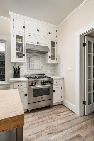 a kitchen with cabinets stove and a wooden floor