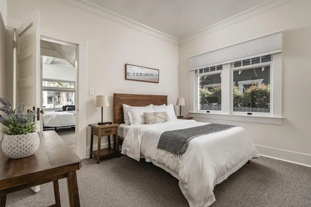 a bedroom with a bed and a table in it with window