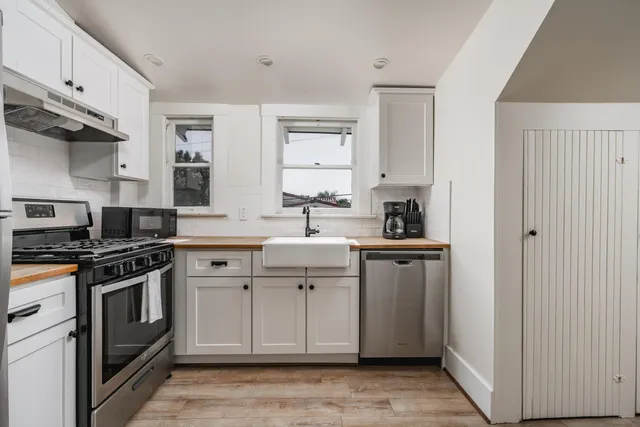 a kitchen with white cabinets and appliances