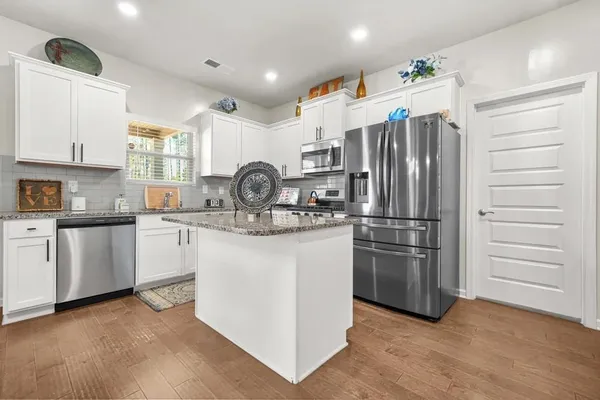 a kitchen with kitchen island stainless steel appliances cabinets and a sink