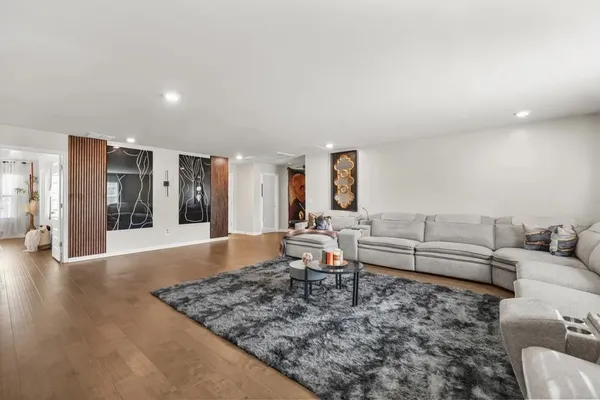 a living room with furniture and wooden floor