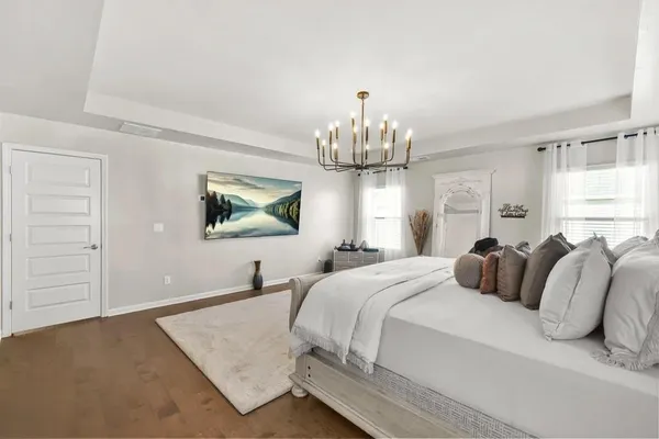 a bedroom with bed and a chandelier