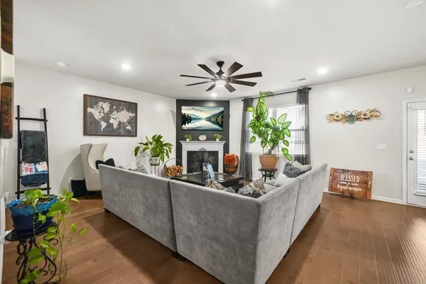 a living room with furniture potted plant and a large window