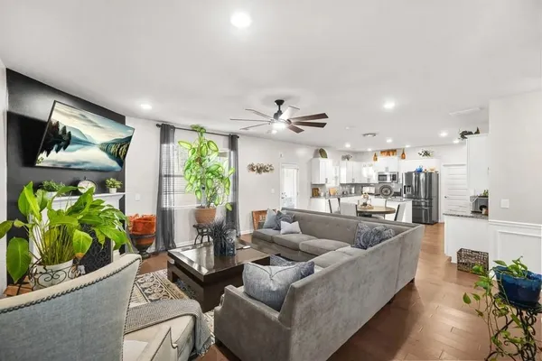a living room with furniture kitchen and a chandelier