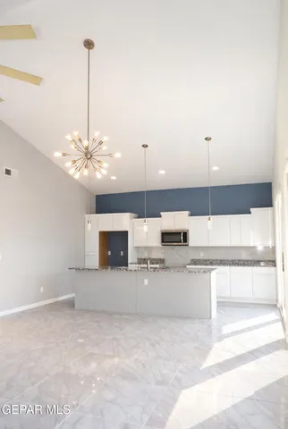 a view of a kitchen with a sink and chandelier