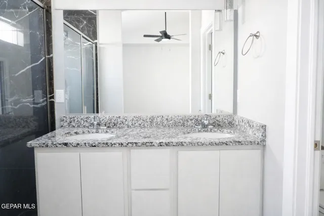 a bathroom with a granite countertop sink and a mirror