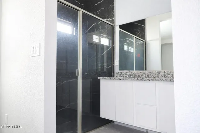 a bathroom with a granite countertop sink and mirror