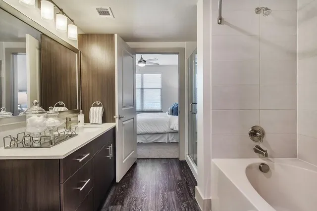 a spacious bathroom with a tub sink and mirror