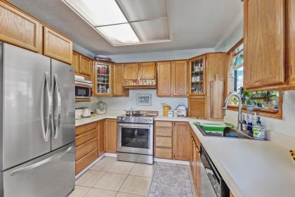 17959 Pesante Road Salinas, CA 93907 - Photo 7 of 24 a kitchen with stainless steel appliances granite countertop a refrigerator a sink dishwasher a stove with white cabinets and wooden floor