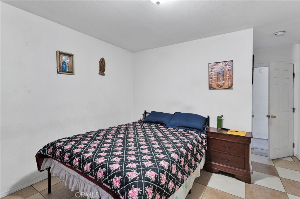 1132 Calhoun Street Redlands, CA 92374 - Photo 19 of 27 a bedroom with a bed and wooden floor