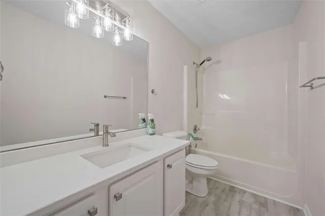 a bathroom with a granite countertop sink a toilet and a mirror