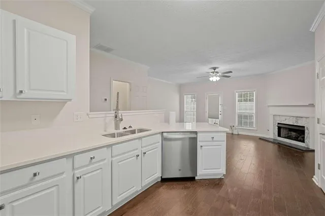a kitchen with a sink cabinets and wooden floor