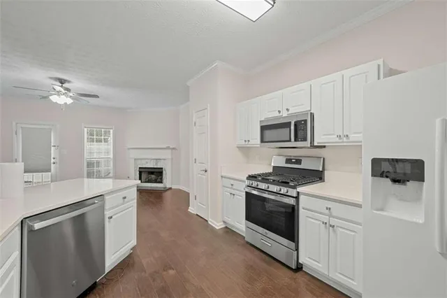 a kitchen with white cabinets and stainless steel appliances