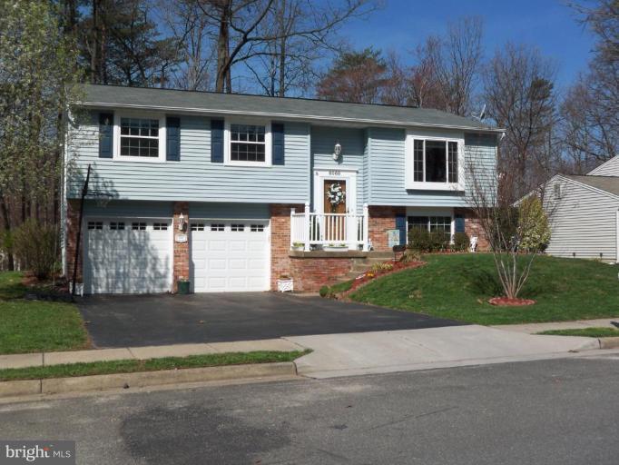 8060 Athena Street Springfield, VA 22153 - Photo 1 of 21 a front view of a house with a garden and garage