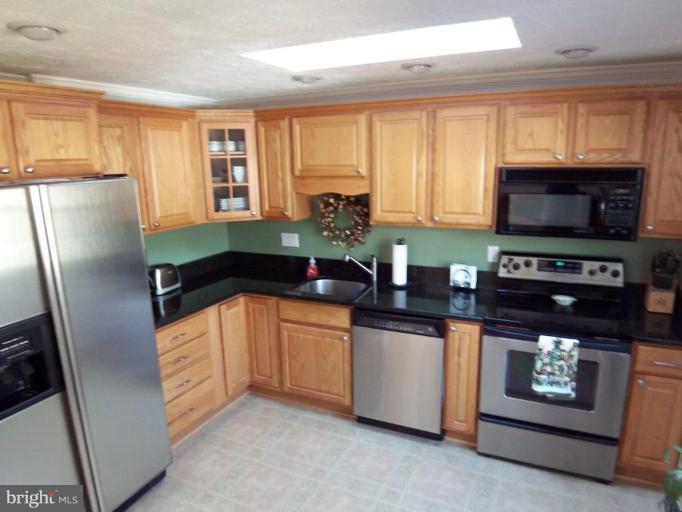 8060 Athena Street Springfield, VA 22153 - Photo 6 of 21 a kitchen with stainless steel appliances a stove microwave and a refrigerator