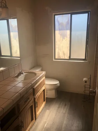 a bathroom with a sink a toilet and a window