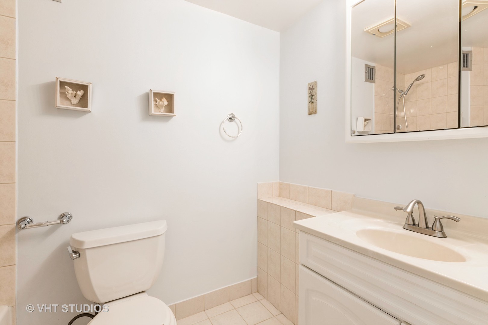 9701 North Dee Road, Unit 5M Niles, IL 60714 - Photo 7 of 21 a bathroom with a toilet a sink and mirror