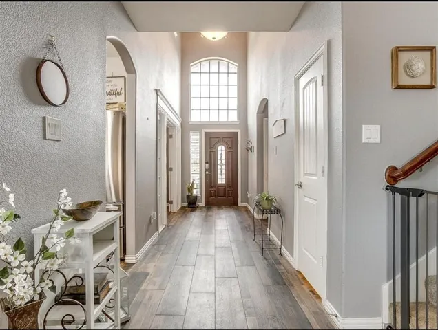a view of a room with lots of white furniture and wooden floor