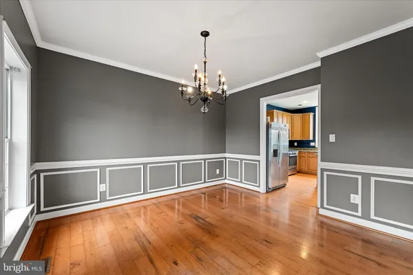 a view of an empty room with wooden floor and a fireplace
