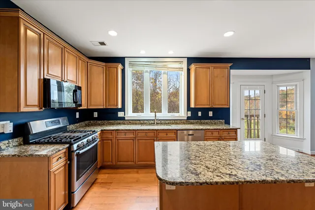 a view of a hallway with wooden floor and windows
