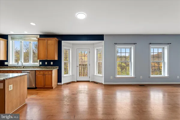an empty room with windows and chandelier fan