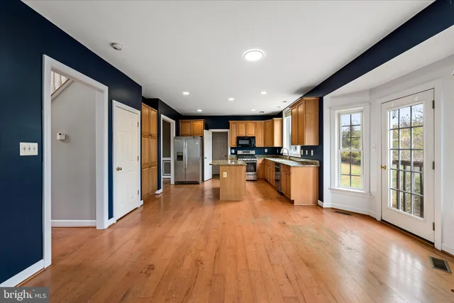 a view of an empty room with a chandelier fan