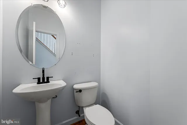 a bathroom with a sink a toilet a mirror and shower