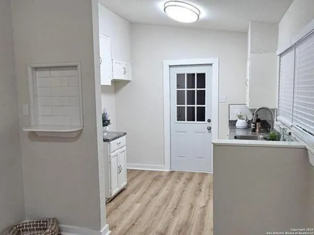 a view of a house with a yard and potted plants