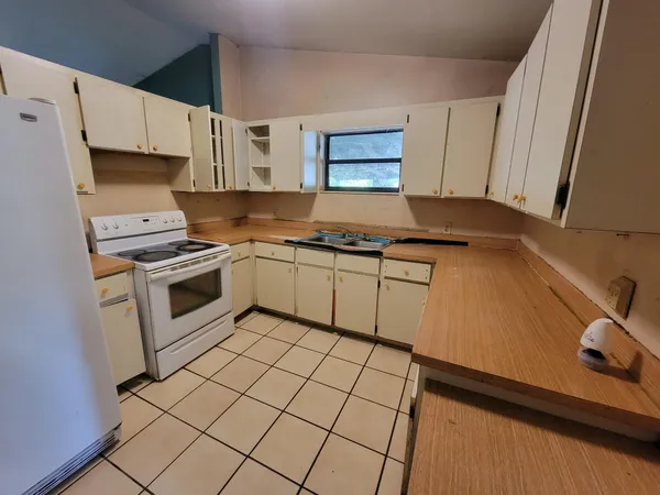 a kitchen with a stove sink and cabinets