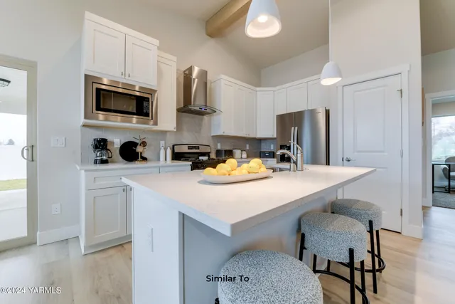 a kitchen with stainless steel appliances a stove a sink a microwave a refrigerator and cabinets