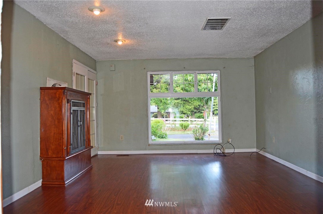 19215 Loganberry Street Southwest Rochester, WA 98579 - Photo 12 of 38 an empty room with wooden floor and windows